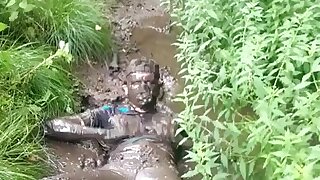 A guy is rolling in the mud in skinny jeans